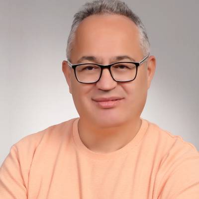 Ömer Adıgüzel’in açık renk kazaklı, gülümseyen portresi.